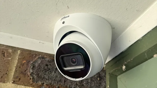 White turret camera at the corner of a painted eave above a window