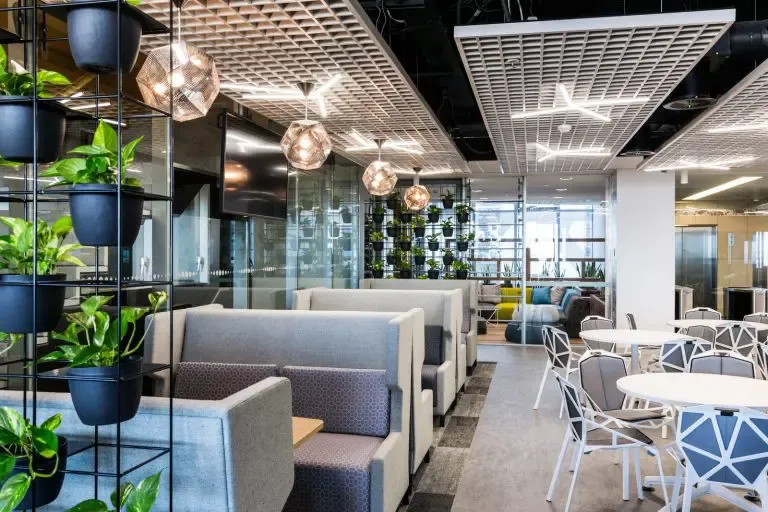 Modern office breakout area with pendant lighting and planter walls