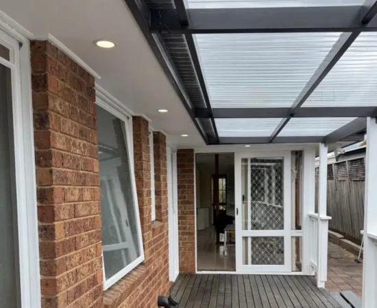 Covered alfresco area at the rear of a brick home