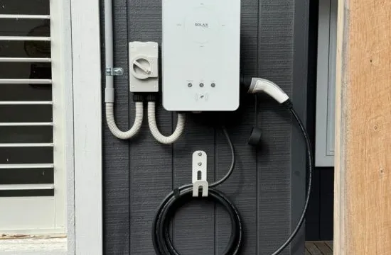 Home EV charger and isolator mounted on a dark weatherboard wall in Mount Eliza
