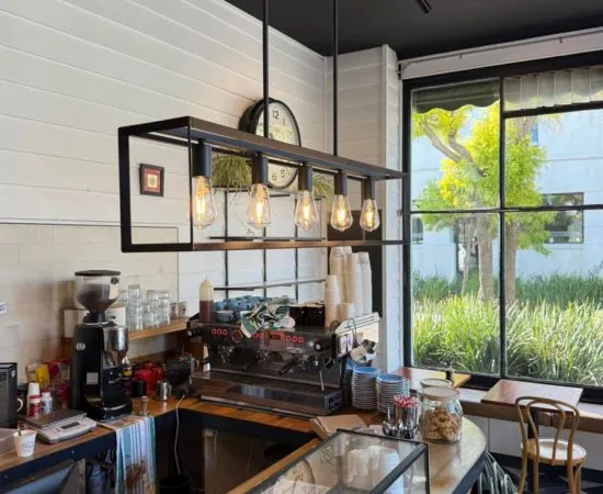 Café counter with industrial pendant lighting installed as part of a hospitality fit-out