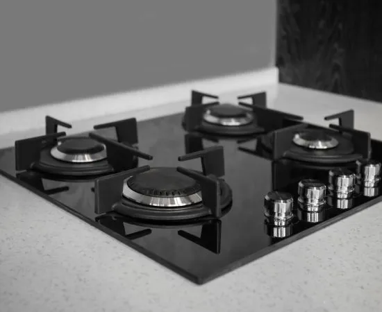Black cooktop installed in a stone kitchen benchtop