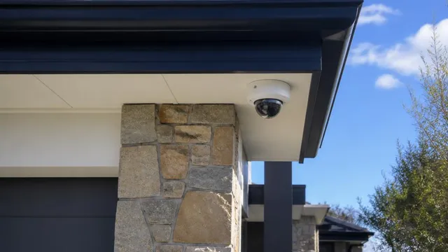 Hard-wired CCTV dome camera fitted under the eaves of a house