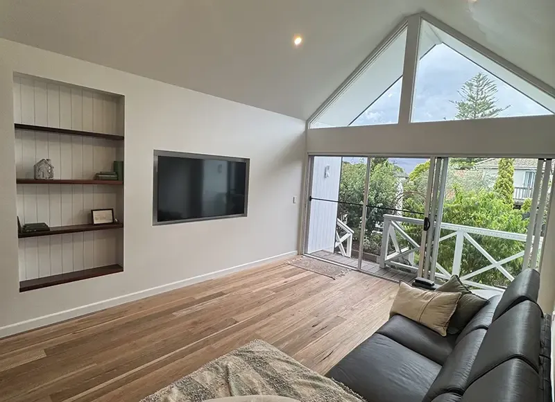 Bright living room with a wall-mounted TV and deck views in a south-east Melbourne home
