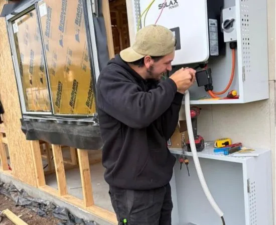 Streamline electrician running cable into a wall-mounted unit on a timber-framed wall